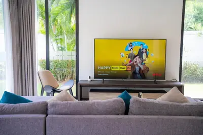 a living room with a couch and a flat screen tv at Modern Minimalist 6 Bedroom Light Luxury Villa Private Pool Golf Course Laguna Park in Bang Tao Beach