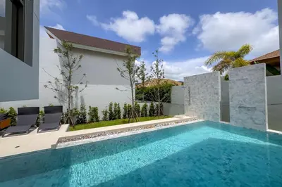 a swimming pool with two chairs next to a house at Brand-New 3BR Designer Pool Villa in Exclusive Residence LuxPride 4 L20 in Bang Tao Beach