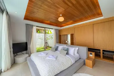 a bedroom with a large bed and a television at Brand-New 3BR Designer Pool Villa in Exclusive Residence LuxPride 4 L20 in Bang Tao Beach