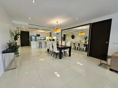 a living room and dining room with a table and chairs at Stylish 2-Bedroom Apartment with Pool Access in Surin Beach