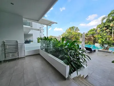 a balcony of a house with a swimming pool at Stylish 2-Bedroom Apartment with Pool Access in Surin Beach