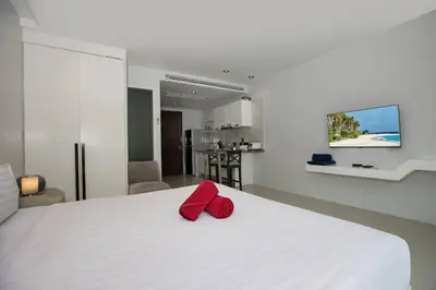 a bedroom with a white bed with red pillows on it at Tropical Retreat near Patong - Emerald Hill 420 in Patong Beach