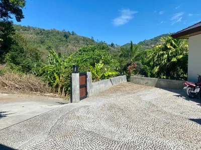 a gate to a house with a mountain in the background at Viewpoint Villa with Private Infinity Pool - 2BR in Rawai Beach