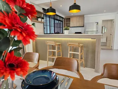 a kitchen and dining room with red flowers on a table at Modern 2 Bedroom Pool Villa in Kamala in Kamala Beach