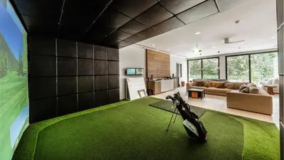 a living room with a golf ball on a green carpet at Villa Amarapura in Ko Lek