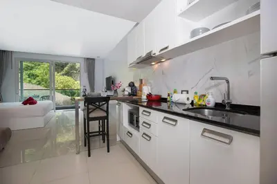 a white kitchen with a sink and a counter at 1Br Horizon Suite at Patong - Emerald Hill 421 in Patong Beach