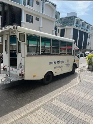 a white bus parked in front of a building at Beachfront Deluxe BR Infinity Pool Patong Phuket in Patong Beach