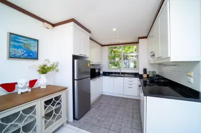 a kitchen with white cabinets and a black refrigerator at Villa Seadream -Kata SeaView Villa-5 Mins to Beach best location in Phuket Town