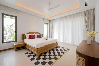 a bedroom with a king sized bed and a desk at Anchan Bangtao 4 Bedroom Pool Luxury Courtyard Villa in Phuket