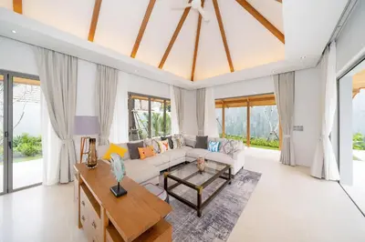 a living room with a couch and a table at Anchan Bangtao 4 Bedroom Pool Luxury Courtyard Villa in Phuket
