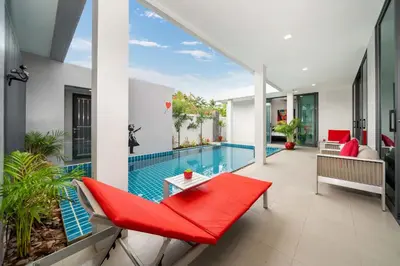 a swimming pool in a house with a red couch and a red bench at Unique Style & Comfort, 2BR Pool Villa DannyLys, near Nai Harn in Rawai Beach