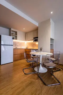 a kitchen with a table and chairs and a refrigerator at Cozy 1 BR beachfront apartment in Bang Tao Beach
