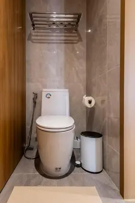 a bathroom with a toilet and a trash can at Cozy 1 BR beachfront apartment in Bang Tao Beach