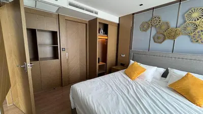 a bedroom with a large bed with yellow pillows at La Vita Rawai 1 Bdr Roof Pool in Rawai Beach