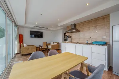 a kitchen and dining room with a wooden table and chairs at C206 Sea-View Condo 5 Min Walk to Kata Beach in Karon Beach