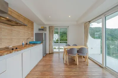 a kitchen with a table and chairs and a large window at C206 Sea-View Condo 5 Min Walk to Kata Beach in Karon Beach