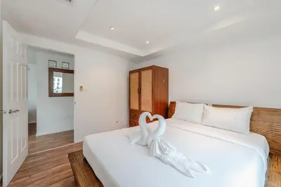 a bedroom with a white bed with a heart decoration on it at C206 Sea-View Condo 5 Min Walk to Kata Beach in Karon Beach
