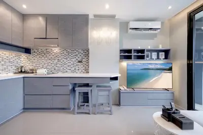 a kitchen with a island and a tv in it at Tropical & Modern Living - Hill View Tropics Kamala Suite CTG L707, Top Amenities & Beach Fun in Kamala Beach