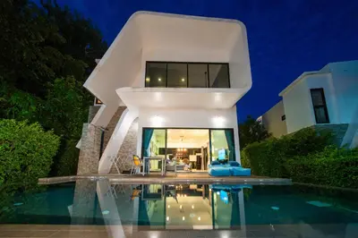 a large white house with a swimming pool at night at \u6f9c\u8fd1 \u7af9\u9690\u5885 Nai Han Waves Edge Retreat in Rawai Beach