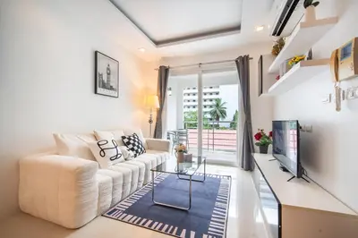 a living room with a white couch and a tv at Patong612\u7cbe\u88c5\u4e00\u5367\u516c\u5bd3 \u7535\u68af\u6cf3\u6c60\u5065\u8eab\u623f \u6b65\u884c\u591c\u5e02\u6d77\u6ee9 in Patong Beach