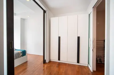 a hallway with white cabinets and a bed in a room at Patong612\u7cbe\u88c5\u4e00\u5367\u516c\u5bd3 \u7535\u68af\u6cf3\u6c60\u5065\u8eab\u623f \u6b65\u884c\u591c\u5e02\u6d77\u6ee9 in Patong Beach