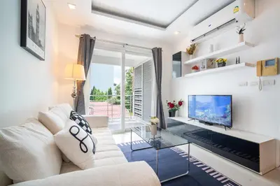 a living room with a white couch and a tv at Patong612\u7cbe\u88c5\u4e00\u5367\u516c\u5bd3 \u7535\u68af\u6cf3\u6c60\u5065\u8eab\u623f \u6b65\u884c\u591c\u5e02\u6d77\u6ee9 in Patong Beach