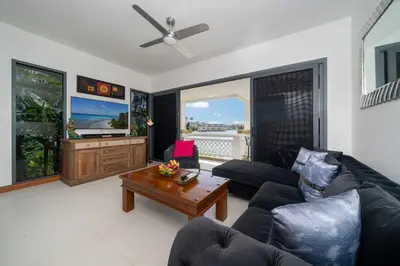 a living room with a couch and a table at Beautiful 2BR Lakeview Apartment in Laguna in Laguna Phuket