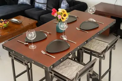 a table with plates and wine glasses and flowers on it at Beautiful 2BR Lakeview Apartment in Laguna in Laguna Phuket