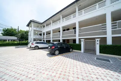 two cars parked in a parking lot in front of a building at Beautiful 2BR Lakeview Apartment in Laguna in Laguna Phuket