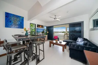 a living room with a table and a couch at Beautiful 2BR Lakeview Apartment in Laguna in Laguna Phuket
