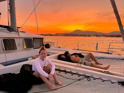 a group of people sitting on a boat at sunset at Catamaran Lagoon 440 Calypso in Ban Bang Chak
