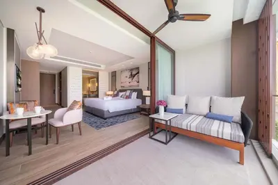 a bedroom with a bed and a living room at Angsana Oceanview Residence Luxurious 2BR Lakeview Apartment in Laguna Phuket