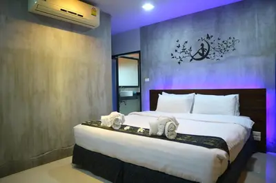 a bedroom with a large bed with towels on it at Baan Norkna Bangtao in Bang Tao Beach