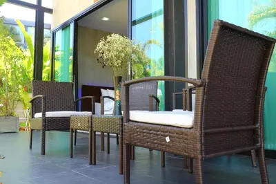 a group of chairs and a table on a patio at Baan Norkna Bangtao in Bang Tao Beach