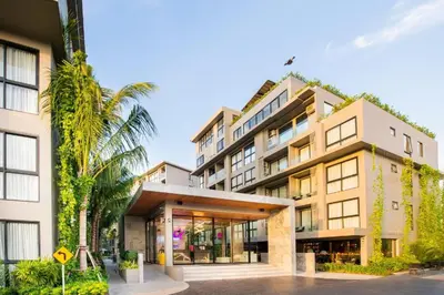 an exterior view of a building with palm trees at Diamond Condominium 1 BR Bangtao beach in Bang Tao Beach