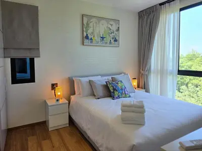 a bedroom with a large white bed with a window at Endless white 2BR apartment-300m to NaiYang Beach in Nai Yang Beach