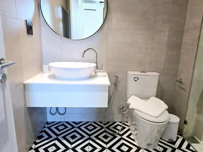 a bathroom with a sink and a toilet and a mirror at Endless white 2BR apartment-300m to NaiYang Beach in Nai Yang Beach