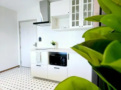 a kitchen with white cabinets and a black microwave at Endless white 2BR apartment-300m to NaiYang Beach in Nai Yang Beach