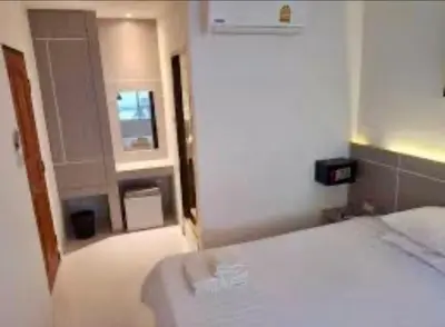 a bedroom with a white bed and a bathroom at SET INN restaurant & bar in Kata Beach