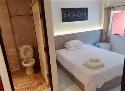 a small bathroom with a bed and a toilet at SET INN restaurant & bar in Kata Beach
