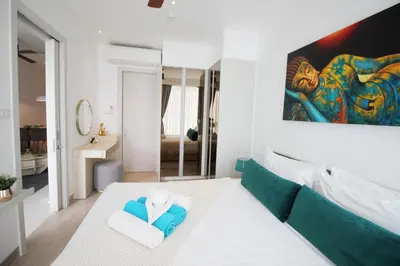a living room with a large painting on the wall at Cassia Lakeview 1BR Apartments, 10min to Beach in Laguna Phuket