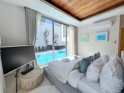 a bedroom with a bed and a tv and a pool at Luxpride 3BR near laguna friendly villa with Garden&pool in Ban Pak Lak