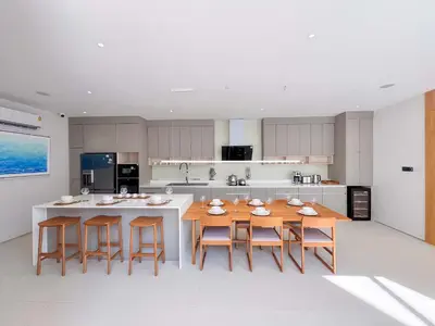 a kitchen with a wooden table and some chairs at Luxpride 3BR near laguna friendly villa with Garden&pool in Ban Pak Lak
