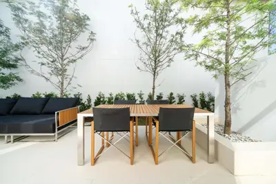 a dining room with a table and chairs and trees at Luxpride 3BR near laguna friendly villa with Garden&pool in Ban Pak Lak