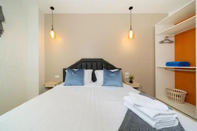 a bedroom with a large white bed with blue pillows at 6BDR patong pool villa by Mp property in Patong Beach