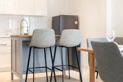 a kitchen with a table with two chairs and a refrigerator at 6BDR patong pool villa by Mp property in Patong Beach