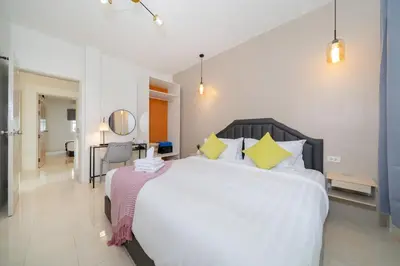a bedroom with a large white bed with yellow pillows at 6BDR patong pool villa by Mp property in Patong Beach