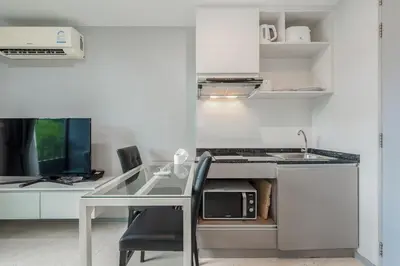 a small kitchen with a table and a microwave at C207 Rooftop Pool & King Bed, Walk to Surin Beach in Surin Beach
