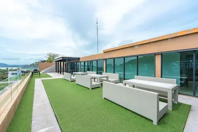 a building with benches and grass on the roof at C207 Rooftop Pool & King Bed, Walk to Surin Beach in Surin Beach
