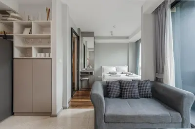 a living room with a couch and a bed at C207 Rooftop Pool & King Bed, Walk to Surin Beach in Surin Beach